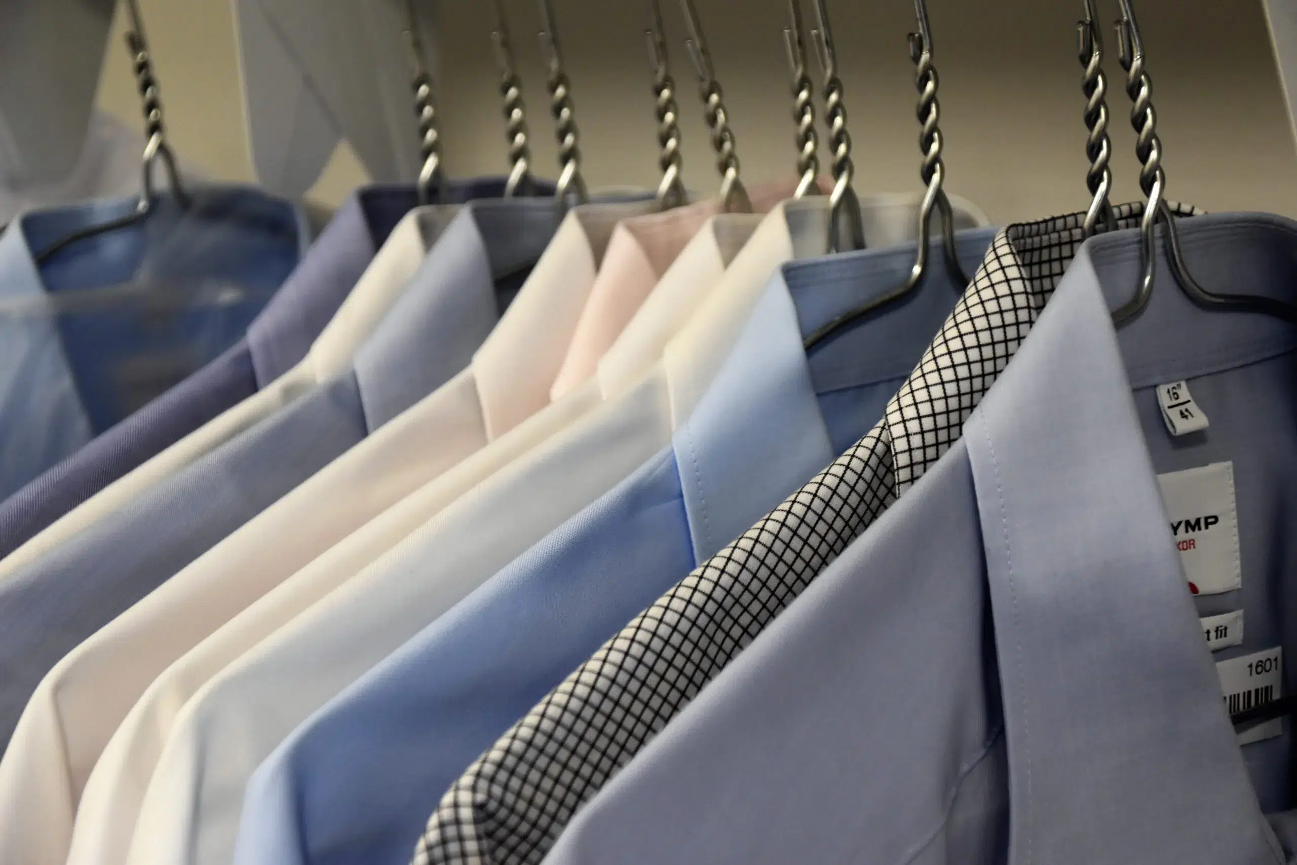 A row of dry cleaned shirts illustrating our textile care division